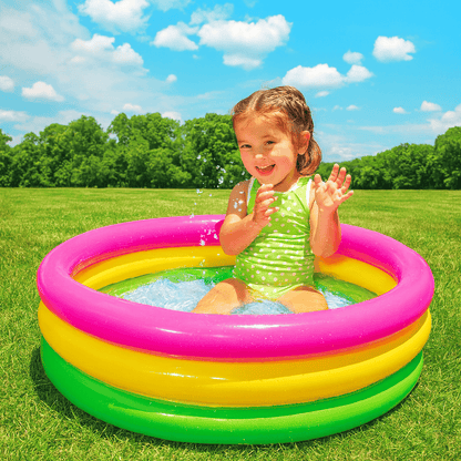 Child playing in a colorful inflatable pool on a sunny day